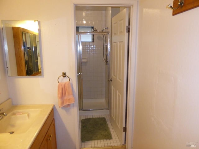 bathroom with tile patterned floors, vanity, and a shower with door