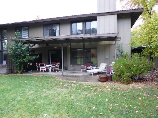 rear view of house featuring a lawn and a patio area