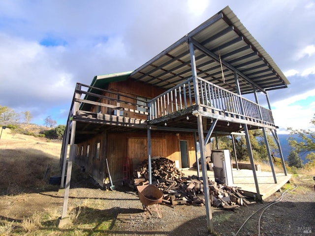 rear view of property featuring a wooden deck