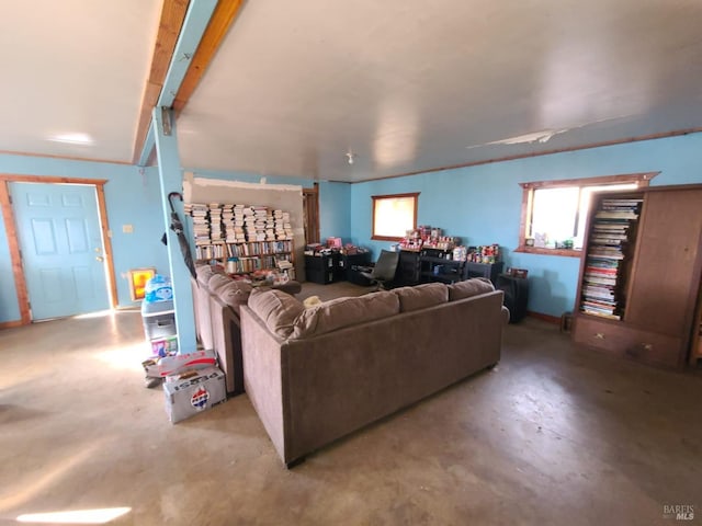 living room featuring beam ceiling and concrete flooring