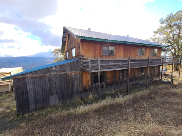 rear view of property featuring a deck with mountain view