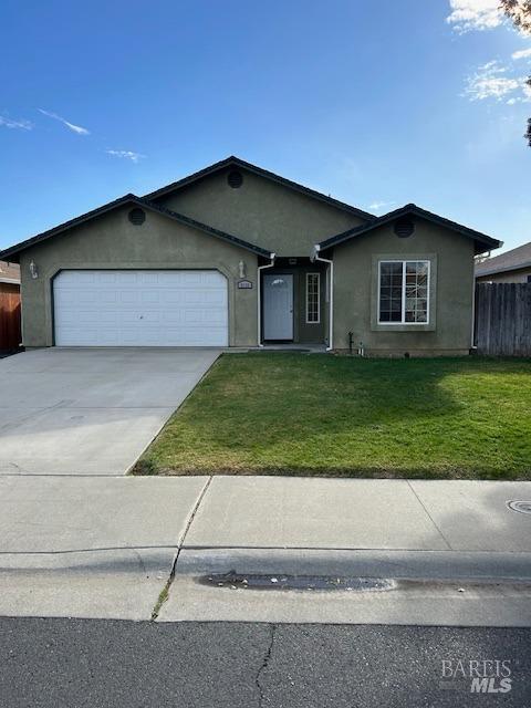 ranch-style house featuring a garage and a front yard