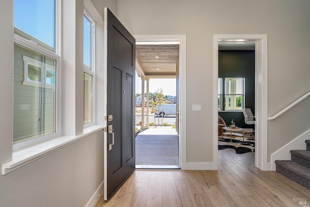 foyer with a towering ceiling and light wood-type flooring