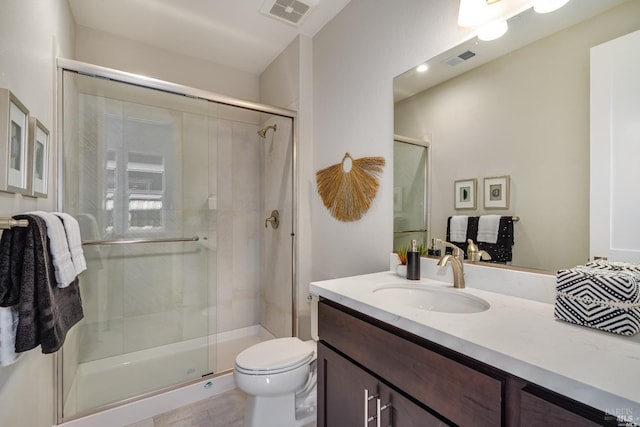 bathroom featuring vanity, an enclosed shower, and toilet