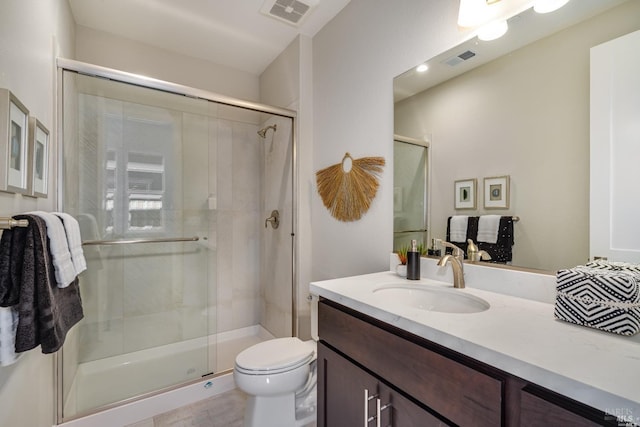 full bathroom with visible vents, toilet, a shower stall, and vanity