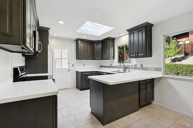 kitchen with plenty of natural light, range with electric cooktop, sink, and a skylight