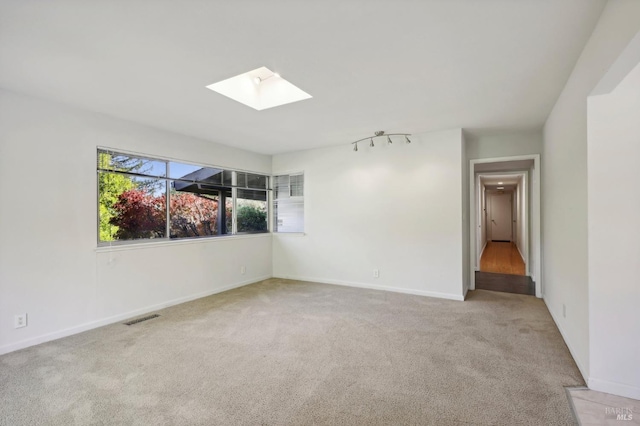 carpeted spare room featuring a skylight