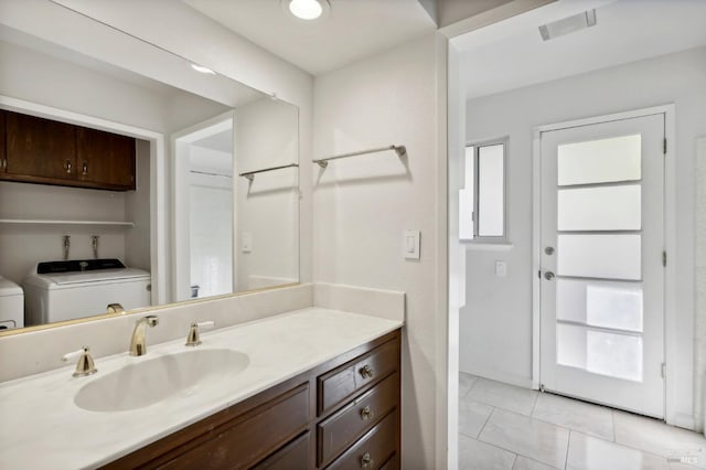 bathroom with toilet, vanity, washer / clothes dryer, and tile patterned floors