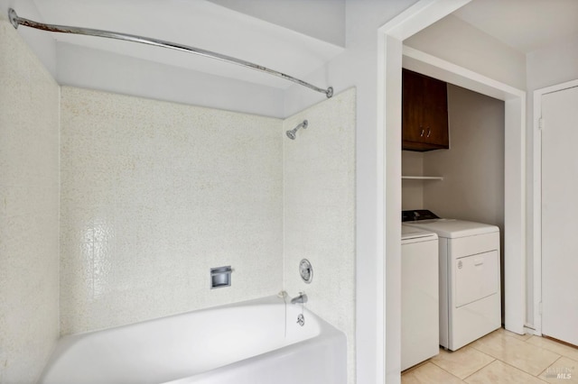 bathroom featuring tub / shower combination, tile patterned flooring, and washing machine and dryer