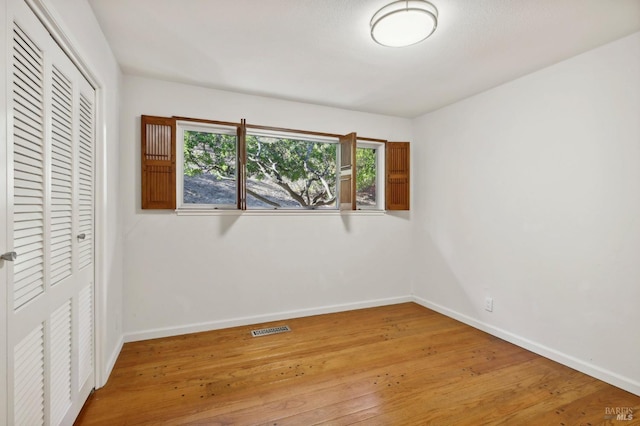 unfurnished bedroom with baseboards, visible vents, a closet, and light wood-type flooring