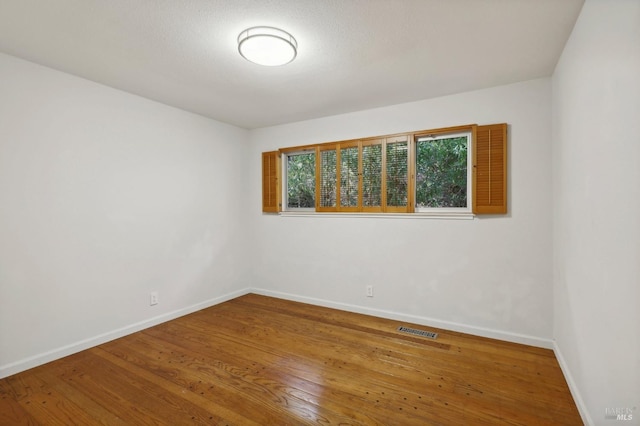 spare room with hardwood / wood-style flooring