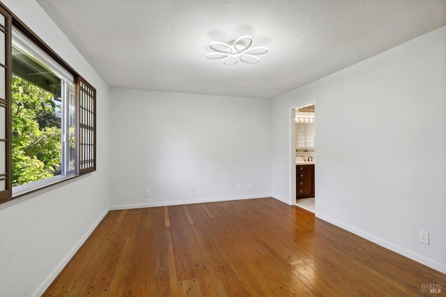 unfurnished room featuring hardwood / wood-style floors and a textured ceiling