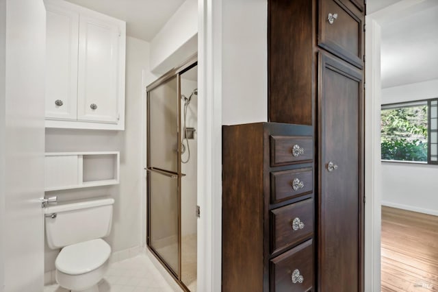 bathroom with hardwood / wood-style flooring, toilet, and an enclosed shower