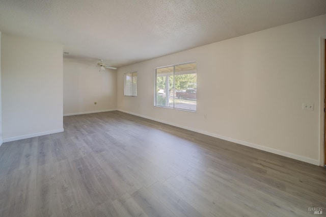 unfurnished room featuring ceiling fan, wood-type flooring, and a textured ceiling