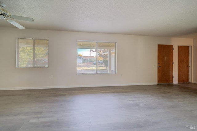 empty room with ceiling fan and a textured ceiling