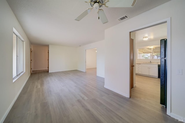 unfurnished room featuring light hardwood / wood-style flooring, a wealth of natural light, and ceiling fan