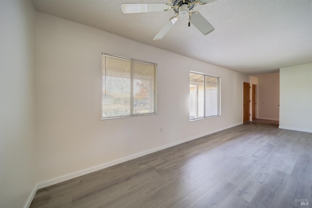 spare room featuring wood-type flooring, a textured ceiling, and ceiling fan