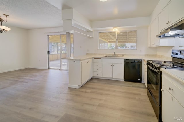 kitchen with hanging light fixtures, kitchen peninsula, white cabinets, and black appliances