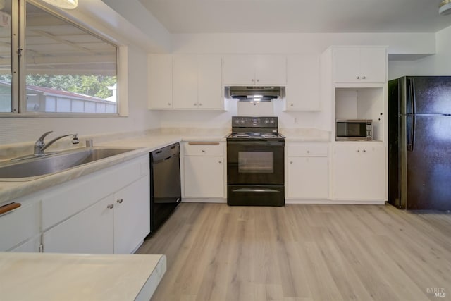 kitchen with white cabinetry, range hood, sink, and black appliances