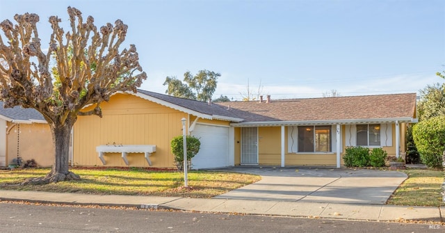 ranch-style house featuring a garage and a front lawn