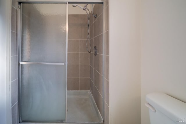 bathroom featuring an enclosed shower and toilet