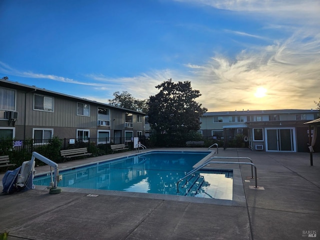 pool at dusk with a patio area