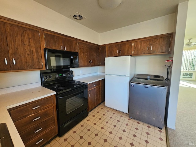 kitchen with black appliances, light colored carpet, and washer / clothes dryer