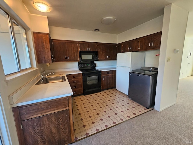 kitchen with light carpet, black appliances, sink, washer / dryer, and dark brown cabinetry