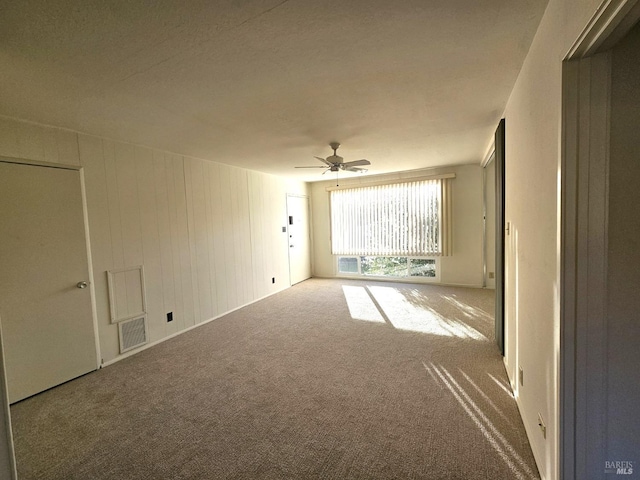 empty room featuring ceiling fan and carpet