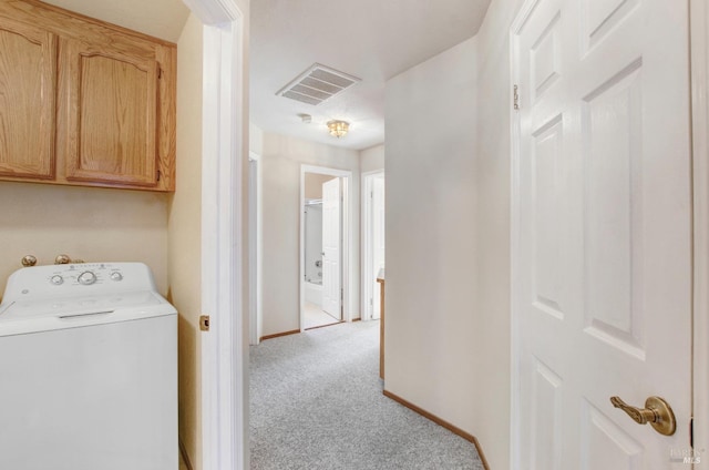 clothes washing area with washer / clothes dryer, cabinets, and light colored carpet