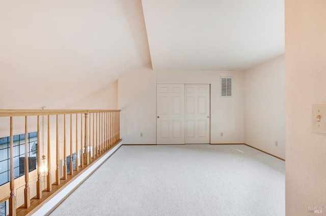 empty room featuring carpet floors and vaulted ceiling