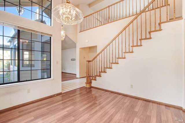 foyer featuring a high ceiling, hardwood / wood-style flooring, and a notable chandelier