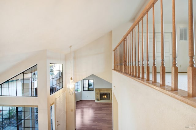 interior space featuring hardwood / wood-style floors, a high ceiling, and a brick fireplace