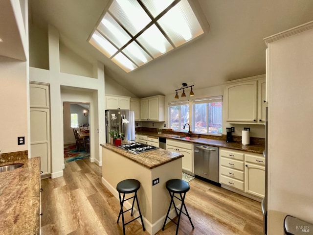 kitchen featuring a center island, a kitchen breakfast bar, sink, light wood-type flooring, and appliances with stainless steel finishes