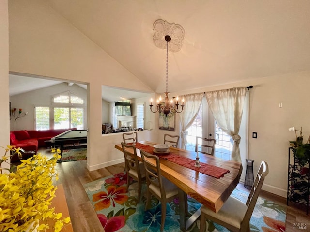 dining area with french doors, vaulted ceiling, a chandelier, hardwood / wood-style floors, and pool table