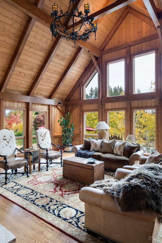 living room with wood ceiling, hardwood / wood-style flooring, high vaulted ceiling, an inviting chandelier, and wood walls