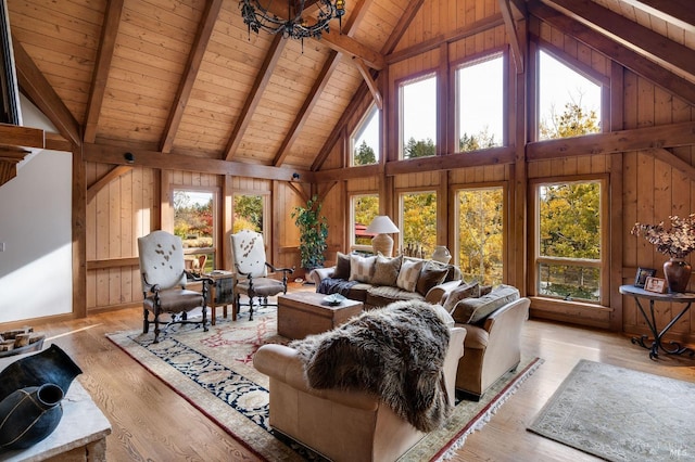 living room with wood walls, light hardwood / wood-style flooring, wooden ceiling, and plenty of natural light