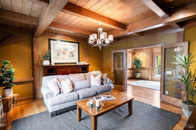 living room with beam ceiling, light wood-type flooring, wooden ceiling, and a chandelier