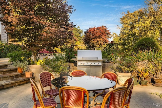 view of patio with exterior kitchen and a grill