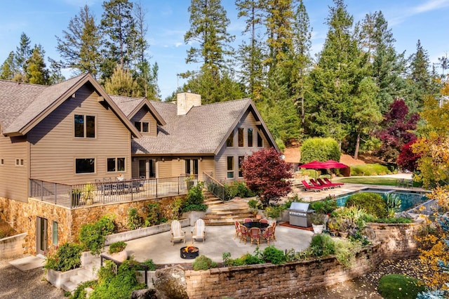 rear view of house with a fire pit and a patio area