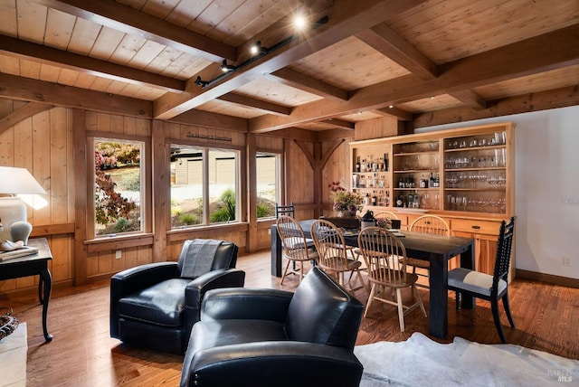 dining area featuring wood walls, wood ceiling, and light wood-type flooring