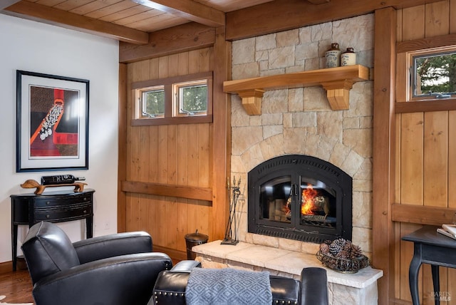 living area featuring wooden walls, hardwood / wood-style floors, beamed ceiling, and wood ceiling