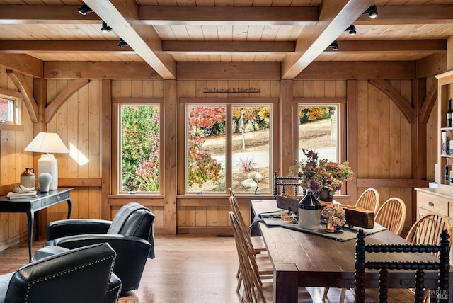 interior space with wood walls, wood ceiling, beam ceiling, and light hardwood / wood-style flooring