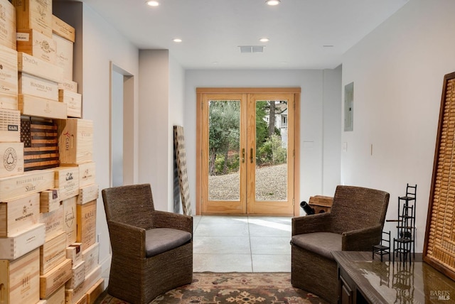 sitting room featuring french doors, electric panel, and light tile patterned flooring