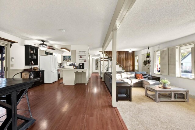 living room with ceiling fan, dark hardwood / wood-style floors, and a textured ceiling