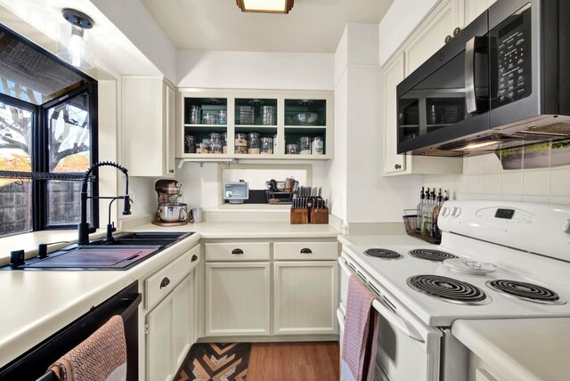 kitchen with white electric stove, dishwasher, tasteful backsplash, sink, and light wood-type flooring