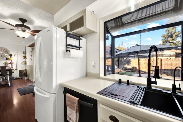 kitchen featuring dishwasher, ceiling fan, white cabinetry, dark hardwood / wood-style flooring, and white fridge