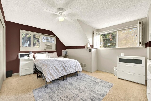 bedroom featuring vaulted ceiling, cooling unit, light colored carpet, ceiling fan, and a textured ceiling