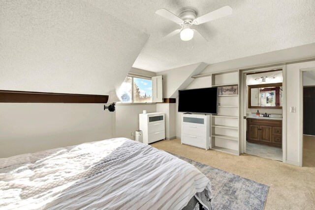 bedroom with connected bathroom, sink, ceiling fan, light carpet, and a textured ceiling