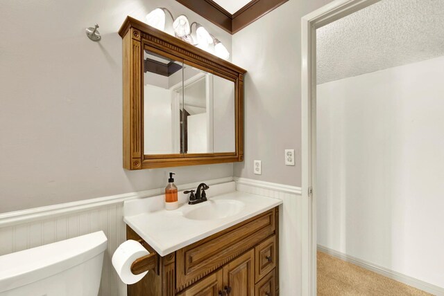 bathroom featuring vanity, a textured ceiling, and toilet